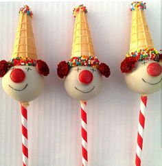 three candy lollipops with clown faces on them