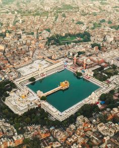 an aerial view of a city with lots of buildings and green water in the middle