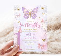 a hand holding up a pink and purple birthday card with gold foil butterflies on it