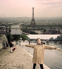 a woman is standing in front of the eiffel tower and posing for pictures