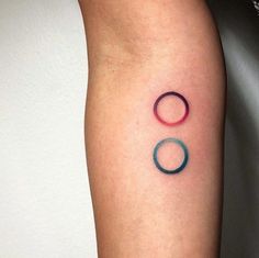 a person with a tattoo on their arm has two rings in the shape of a circle