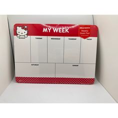 a hello kitty desk calendar is displayed on a white surface with red polka dot border