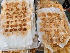 two trays filled with different types of food on top of each other in wrappers