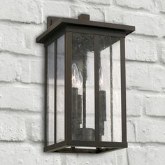 an outdoor light on the side of a white brick wall with three lights in it