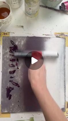 someone is using a brush to paint on a piece of paper