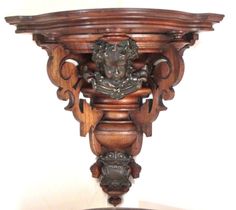 an ornate wooden shelf with a statue on top