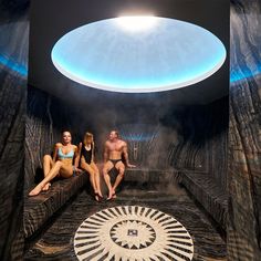 three people are sitting in a steam room