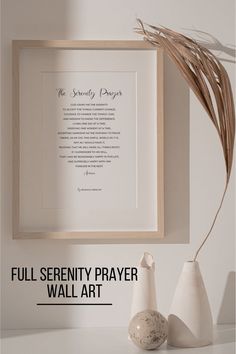 two white vases sitting on top of a table next to a framed poem in a wooden frame