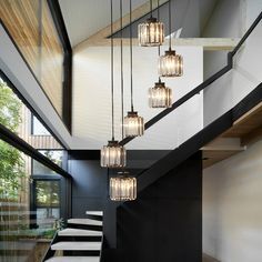 an indoor area with stairs and chandelier hanging from it's ceiling,