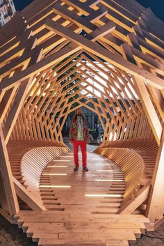 a person standing in front of a wooden structure that looks like it is made out of wood