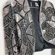 Vintage Silk Beaded Jacket Ornate Heavy Silver Metallic Bolero Loehmann's Black And Silver Sequin And Beading In Art Deco Design Has Had Designer Label Removed As Shown In Photo - But Still Has Vintage Loehmann's Tag Attached Size Small One Shoulder Has Slight Flaw In Sequins As Shown In Final Photo - Otherwise Stunning, No Other Flaws I Can Find This Is A Heavy, Gorgeous, Rare, Vintage Jacket. Perfect For Holidays, Weddings Silver Sequined Outerwear For Evening, Silver Sequined Evening Outerwear, Fitted Silver Sequined Outerwear, Elegant Silver Sequined Outerwear, Silver Long Sleeve Outerwear For Evening, Silver Long Sleeve Evening Outerwear, Silver Glamorous Formal Outerwear, Glamorous Silver Formal Outerwear, Black Vest Dress