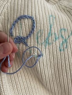 someone is crocheting together with yarn on the floor next to a sweater that says happy birthday