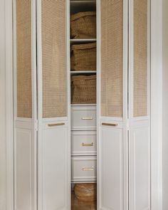 an open closet with wicker doors and drawers