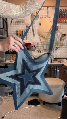 a person holding up a blue star shaped object in a room filled with crafting supplies