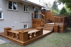 a wooden deck with benches in front of a house