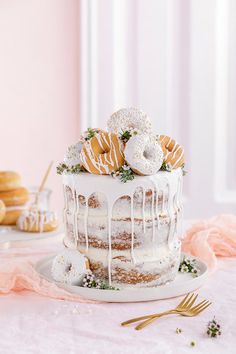 a white cake with frosting and donuts on top