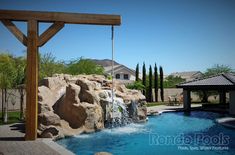 a backyard with a pool and waterfall in the middle