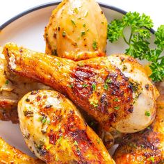 some chicken legs are on a plate with parsley