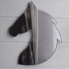 a mirror that is on the wall with a horse's head cut out of it