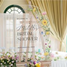 a wooden easel with flowers on it for a bridal shower