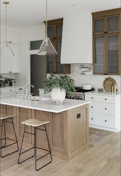 a kitchen island with two stools in front of it