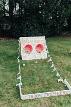 two red bowls sitting on top of a grass covered field next to a sign that says throw frisbees