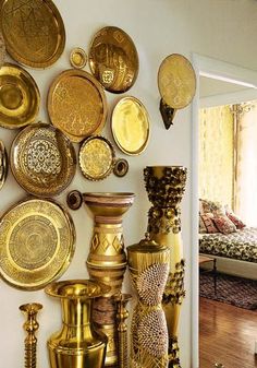 an image of gold plates and vases on the wall in front of a couch