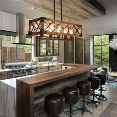 a kitchen with an island and bar stools in front of the counter top that is made out of wood