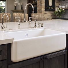 a white kitchen sink sitting under a faucet next to a stove top oven