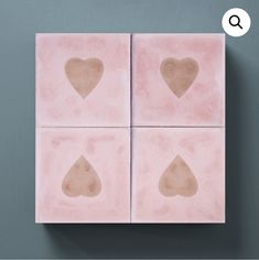 four square tiles with hearts on them against a gray background and the word q above it