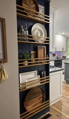 a kitchen with white cabinets and wooden shelves filled with dishes on top of each shelf