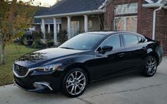 a black car parked in front of a house