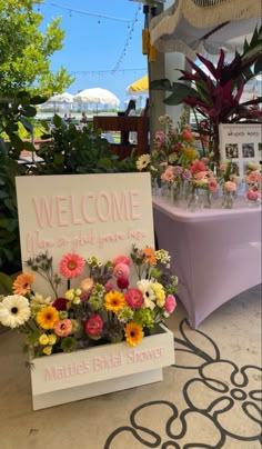 a welcome sign and flowers are on display