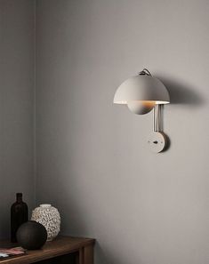 a white lamp on the wall next to a table