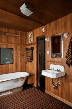 a bathroom with wood paneling and a claw foot tub