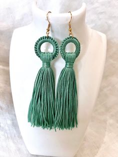 Please Read Full Description These tassel earrings are made from a lovely silky turquoise thread.  The tassels are suspended from a decorative circle design which adds a unique touch to these earrings.  They hang nicely from the earlobes with stainless steel wire hooks, creating nice movement.  Perfect for adding a pop of color, or a bohemian flair to both casual and formal attire.  I send all my earrings out on an earring card in case you are buying as a gift. Measurements:  5" Long from top of earring hook to bottom of tassel. FREE DOMESTIC SHIPPING   My vintage finds are all pre-owned and pre-used. Please expect your item to show signs of both. I inspect all of my items and try to give you the most accurate description possible. Please feel free to contact me if you have any questions a Cheap Green Earrings With Latkans, Affordable Turquoise Bohemian Tassel Earrings, Cheap Turquoise Statement Earrings, Earring Cards, Circle Design, Turquoise Color, Tassel Earrings, Vintage Finds, Tassels