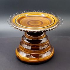 a brown and yellow plate sitting on top of a black table next to a gray wall