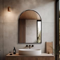 a bathroom with a sink, mirror and light fixture on the wall next to it