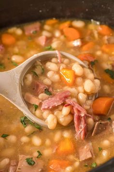 a ladle full of soup with ham and beans