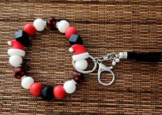 a red, white and black beaded bracelet on a bamboo mat with a leather charm