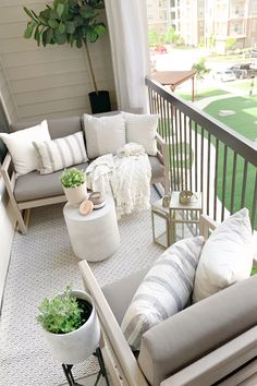 a balcony with couches, chairs and potted plants