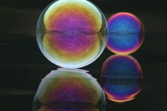 two colorful balls are reflected in the water