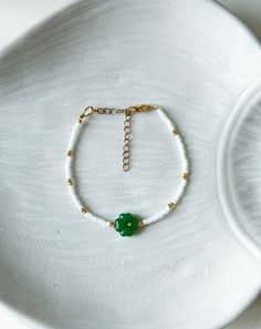 Add a touch of luck and charm to your jewelry collection with this beautiful Green Clover Bracelet. This dainty and elegant piece features tiny green clover charms alongside delicate beads, creating a unique Blossom Bracelet that will surely bring good luck to its wearer. Perfect as a gift for her, this charming bracelet makes a thoughtful Anniversary Gift or a lovely addition to any jewelry lover's collection. Embrace the symbolism of good luck with this stunning accessory and explore endless Gift Ideas for any occasion. 🌷Made to order - 100% hand made 🌷Material - High quality Miyuki seed beads and Preciosa seed beads, lamp-work green clover, stainless steel  🌷Bracelet - default size is 15 cm + 5cm ( Please let me know is you need other size. You can wrap your hand with a rope and meas Elegant Green Bracelet For Good Luck, Elegant Beaded Bracelets With Flower Charm And Round Beads, Dainty Jewelry With Flower Charm And Round Beads, Handmade White Good Luck Bracelets, Elegant Hand-strung Bracelets For Good Luck, Green Beaded Bracelets With Flower Charm For Gift, Green Bracelet With Flower Charm As Gift, Good Luck Beaded Bracelet Jewelry, Beaded Bracelet Jewelry For Good Luck