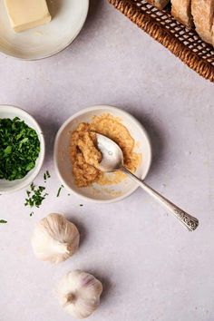 garlic, parsley and butter in bowls next to bread