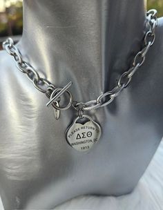 a close up of a metal mannequin wearing a necklace with a tag on it