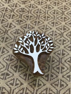 a wooden brooch with a white tree on it