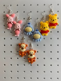 winnie the pooh and friends keychains hanging from hooks on a pegboard