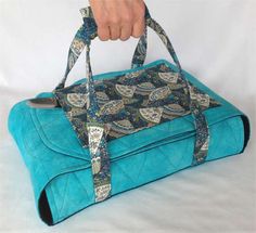 a person holding onto a blue bag with an animal print on it and the handles