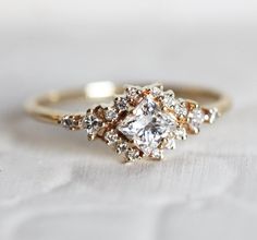 a close up of a diamond ring on a white surface