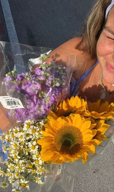 a woman is laying down with flowers in front of her and smiling at the camera